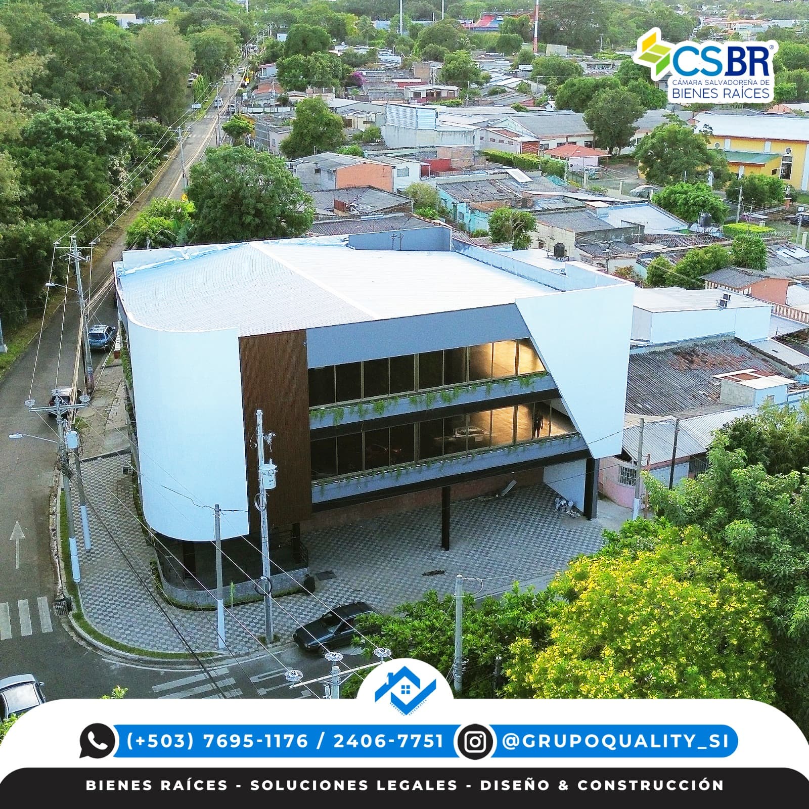Edificio moderno de tres niveles con fachada blanca curva y ventanales en un entorno arbolado.
